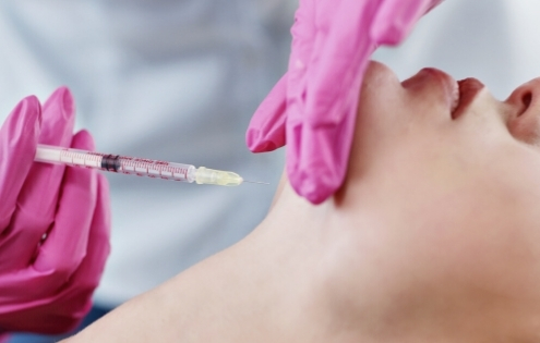 woman gets injection into under chin fat
